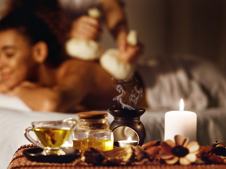 spa treatment room, guest receiving a massage, tray of oils and candle