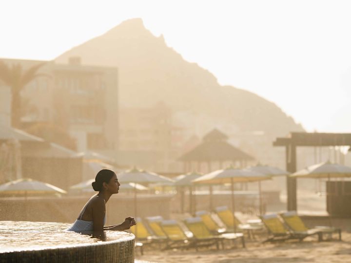 プールにビーチとデッキチェアを備えた女性