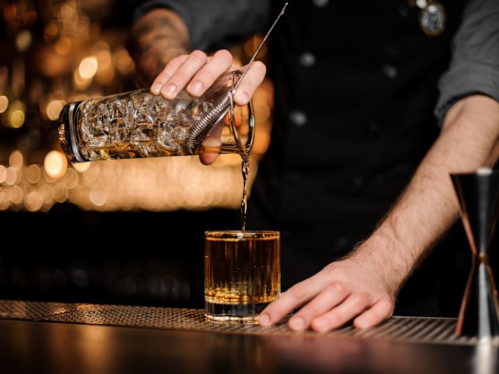 Barman făcând un cocktail la bar