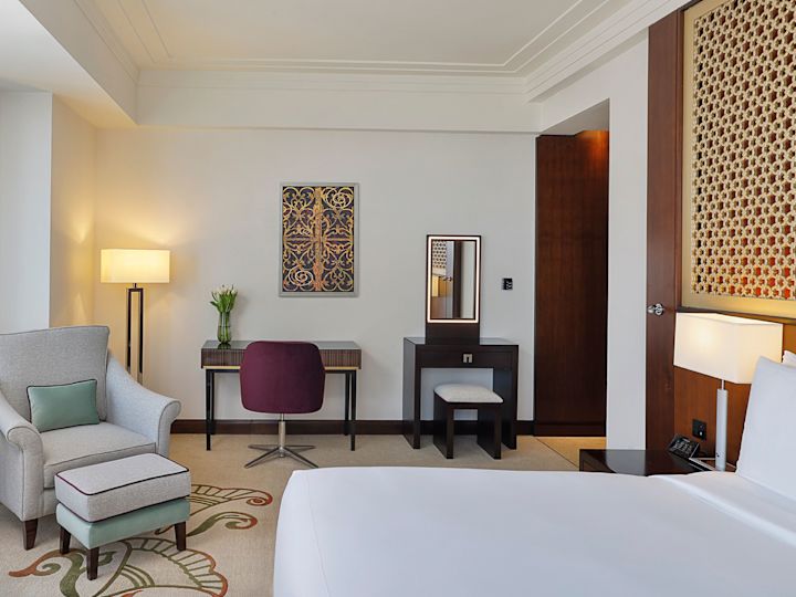 Armchair, Desk and Bed in a Guest Room with City View