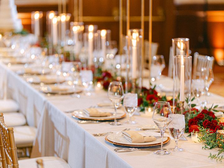 Nastavení stolu s červenými květy a svíčkami pro svatební oslavu