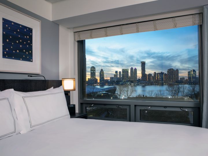 Bed in room with view of Hudson River outside