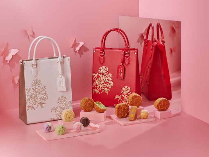 Mooncakes and Decorated Red and White Bags on a Table at Golden Peony