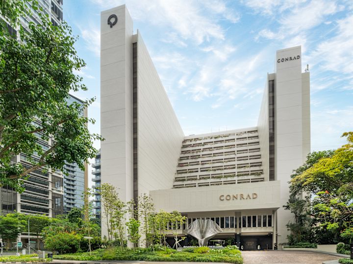 Fasada hotelu z podjazdem i otaczającymi drzewami