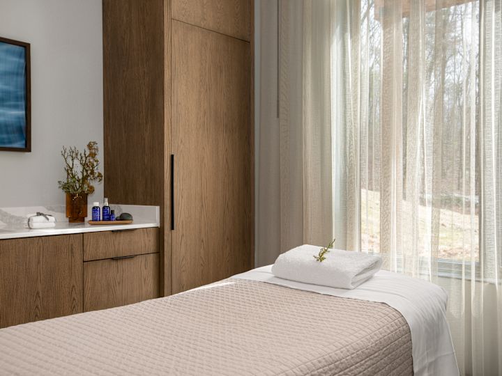 Spa treatment room with a table and cabinets.