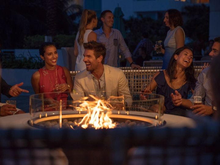 group of people laughing around a fire