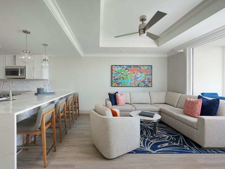Lounge area with art on wall and view of kitchen