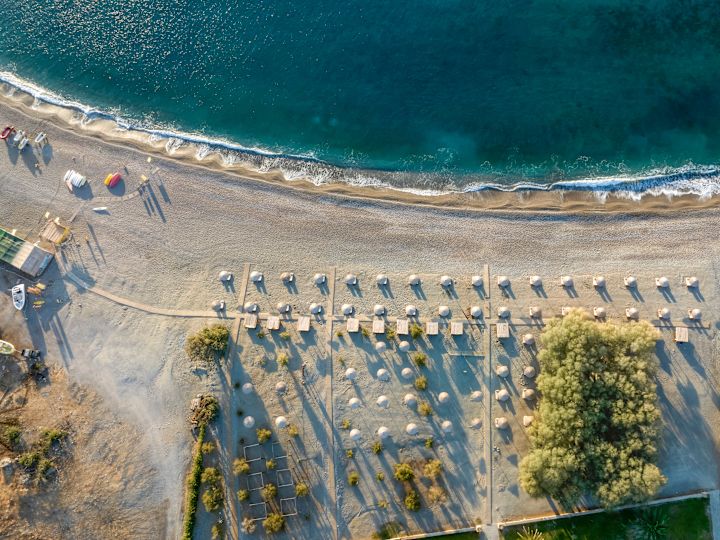 Vedere aeriană a scaunelor Lounge sub umbrelele și Cabana la plajă