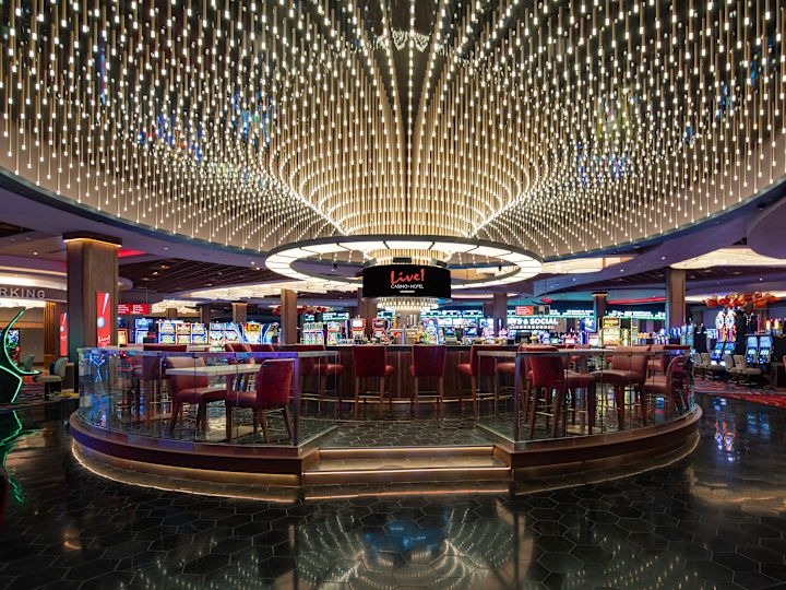 카지노 층의 중앙 바, 그 위에 스크린과 대형 원형 조명 기구가 있는 인근 슬롯