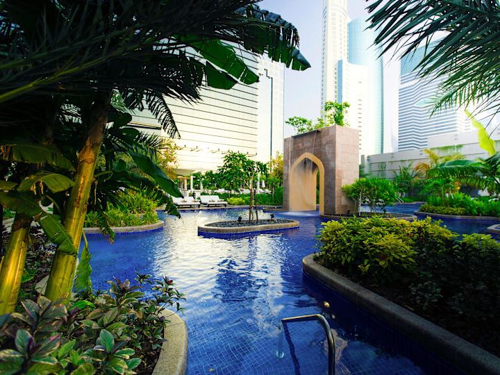Outdoor Pool Area with Cascade and Gardens with Palm Trees