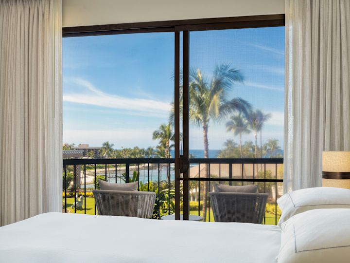 Bed in a Guest Room with Ocean View from Balcony with Seating Area