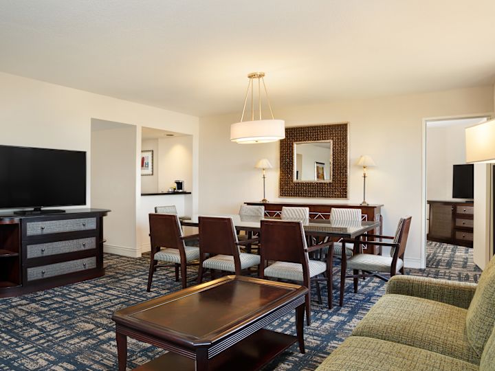Guestroom lounge area with couch, TV and dining table