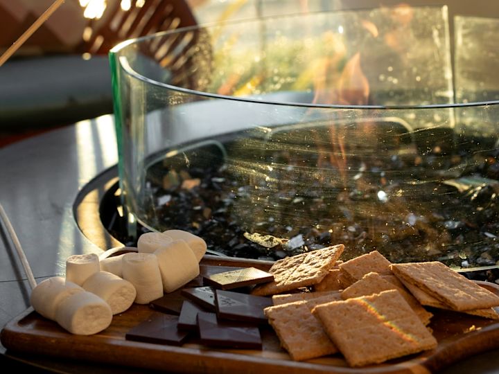 O persoană care ține un Marshmallow în foc pentru a face mai multe lucruri