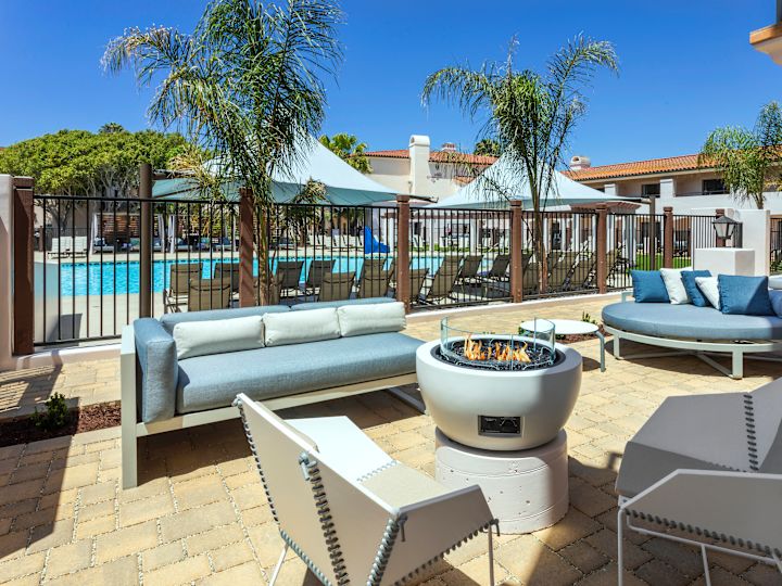 patio kamar tamu, sofa, kursi, lubang api, pemandangan kolam renang