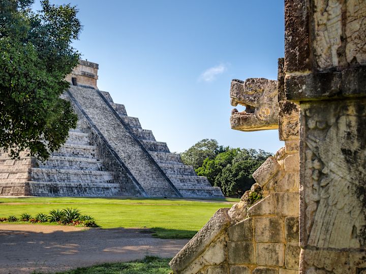 A carved jaguar head on the exterior of a Mayan temple.