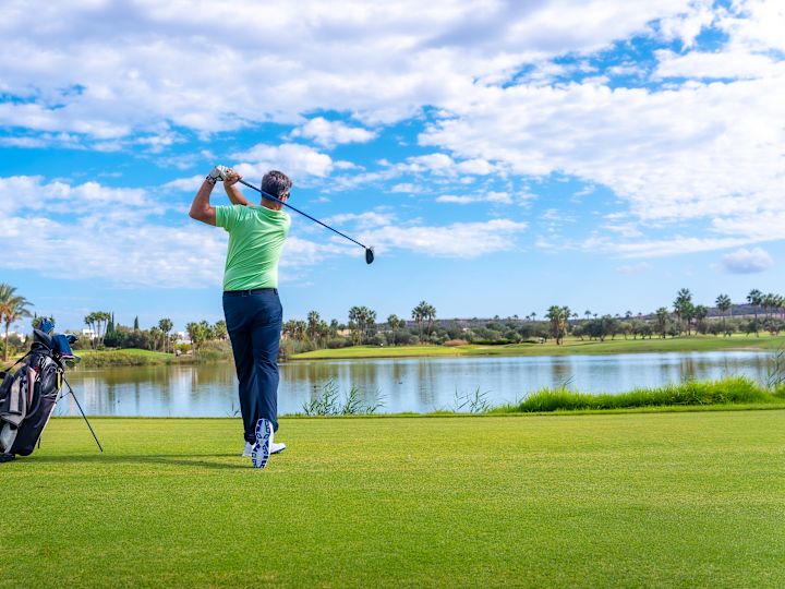 Une personne jouant au golf par une journée ensoleillée.