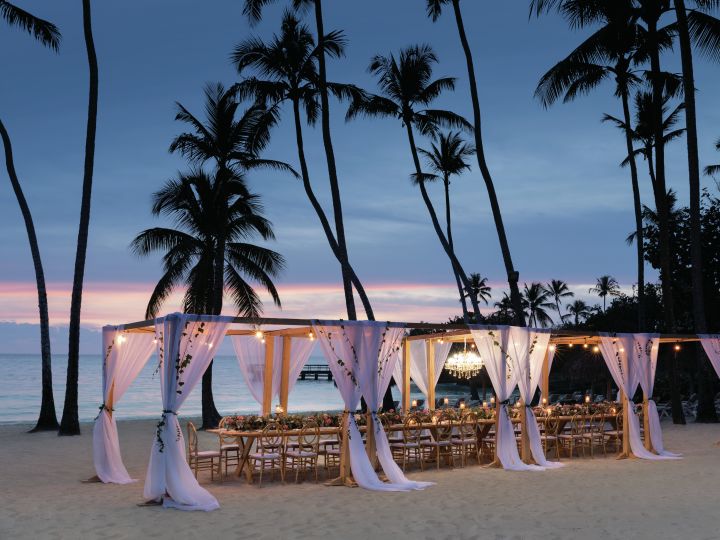 a long wedding reception table on a beach