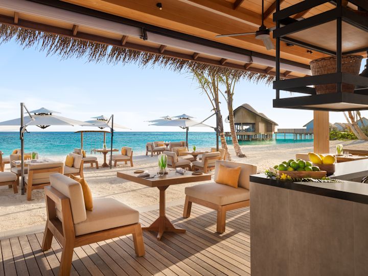 Outdoor bar and seating area on beach with sea view