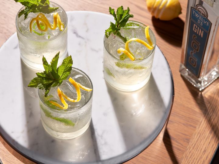 Gros plan de trois verres de gin tonic avec une touche citronnée