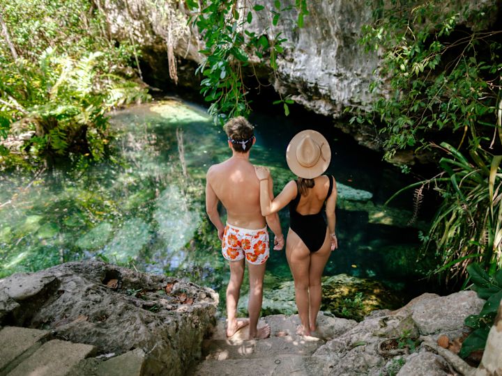 man and woman standing on rocks overlooking water