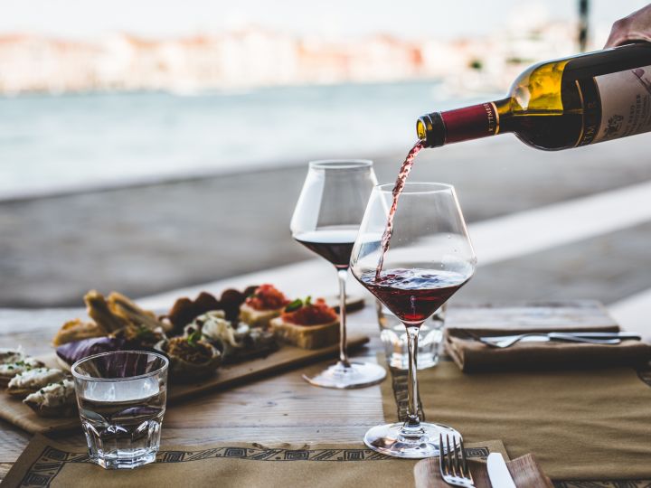 Du vin est versé dans des verres avec des repas derrière
