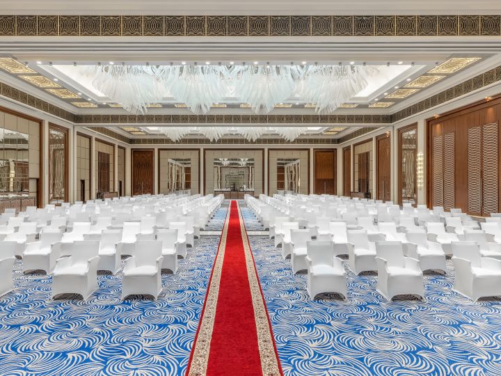 Ballroom setup with white covered chairs for a conference