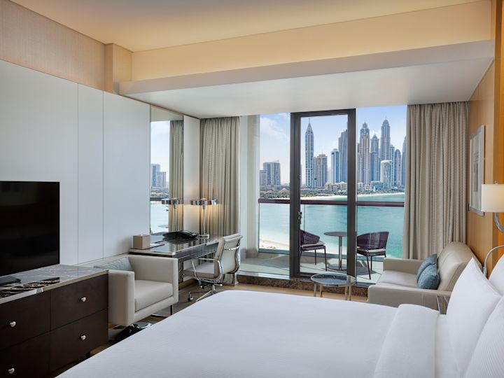 Chambre avec très grand lit, téléviseur, bureau et vue sur la marina