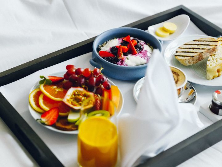 Closeup of a tray of breakfast food on a bed