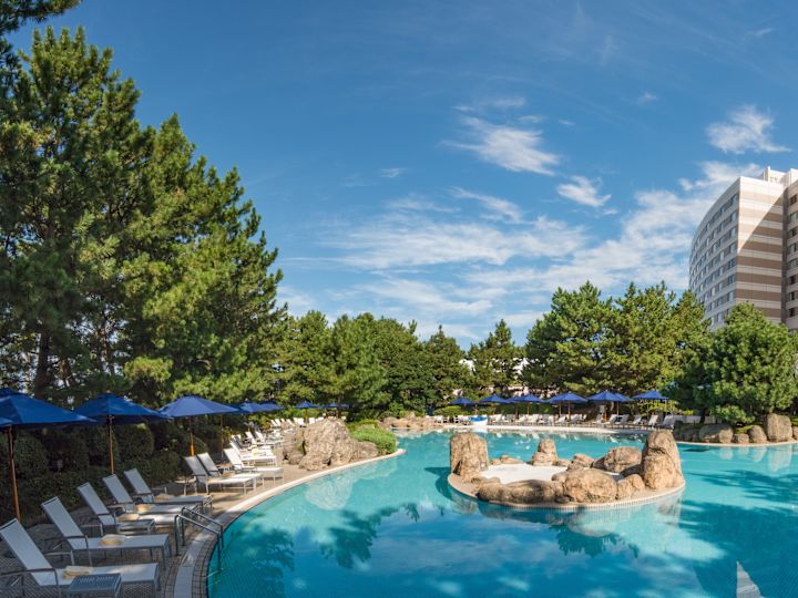 วิวในเวลากลางวันของ Blue Sun Umbrellas และ Relaxation Loungers by Pool