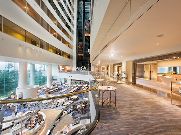 Corridor With View of Elevator Bay and Seating by Large Windows on Lower Level