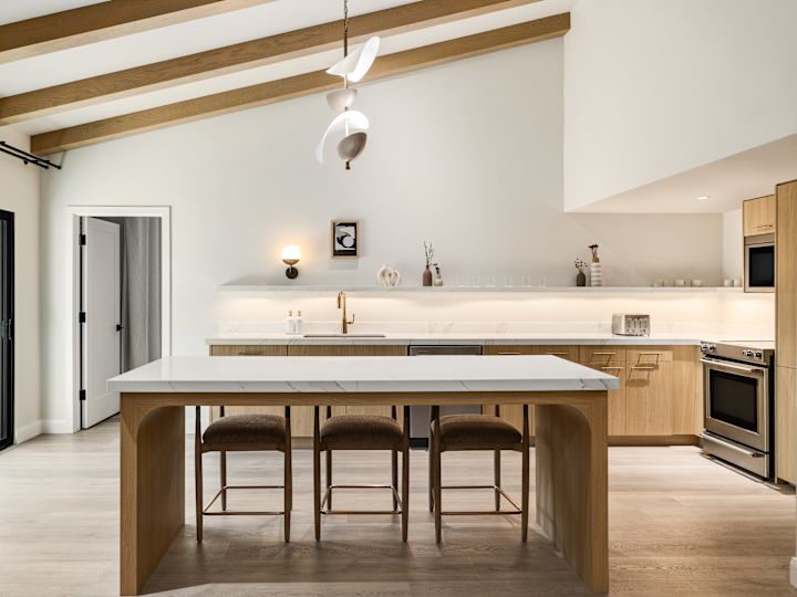 Serene guest villa kitchen with large marble island and stools