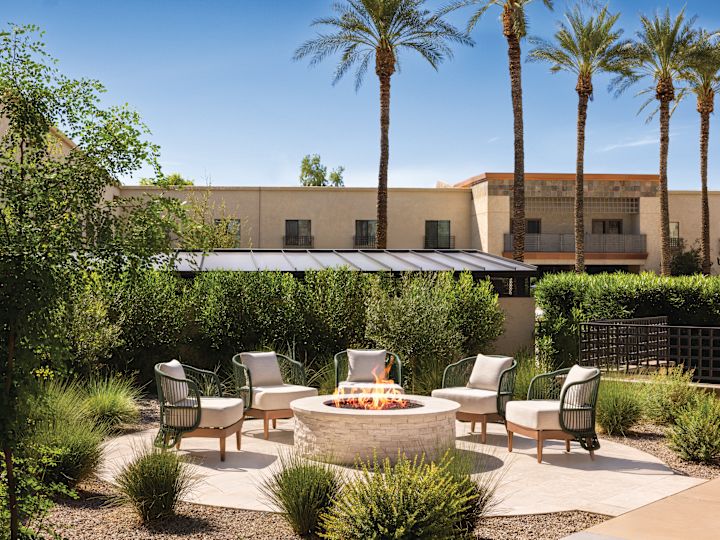 Patio with a fire pit and soft seating.