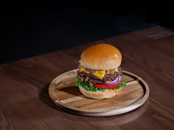 Burger pe o farfurie de lemn
