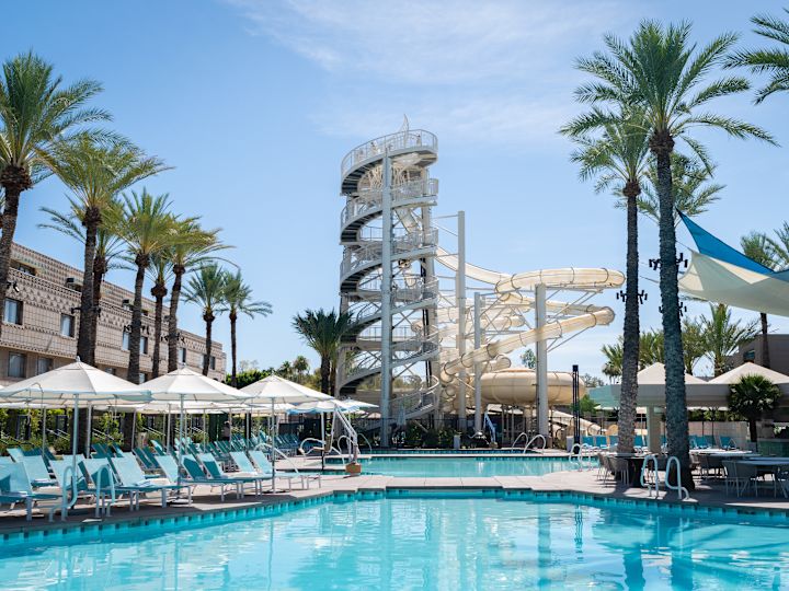 Vista da piscina, com espreguiçadeiras e toboáguas