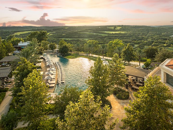 Hotel exterior, with outdoor pool with loungers and trees