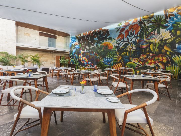 Sitzbereich mit Tischen und Stühlen mit großem Wandbild