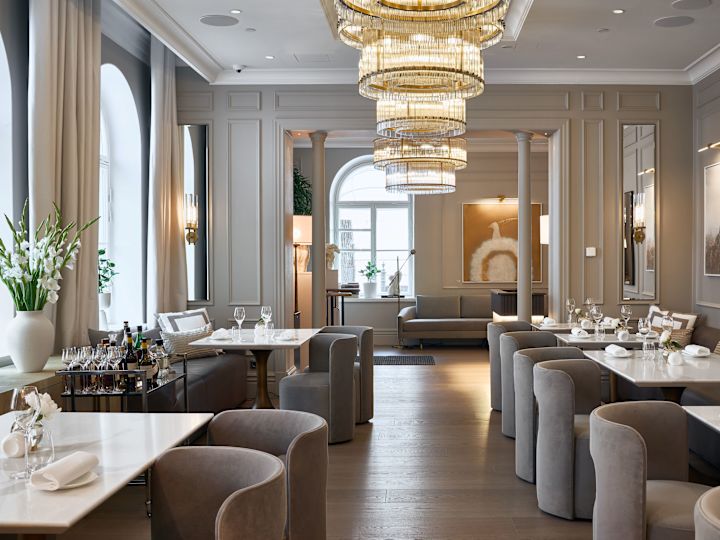 柔らかな椅子、自然光、シャンデリアを備えたレストラン