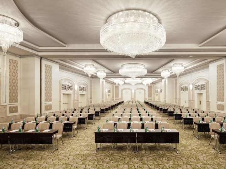 Ballroom with Tray Ceiling, Crystal Chandeliers, and Tables and Chairs Arranged in Classroom Layout