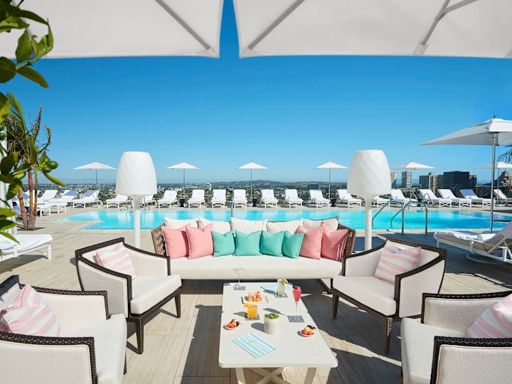 Outdoor pool seating area with lounge chairs, and table surrounded by sofa and chairs
