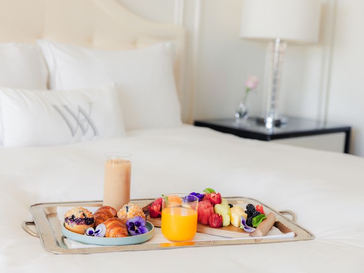 Restaurant în cameră, un pat mare cu preparate pentru micul dejun pe o tavă