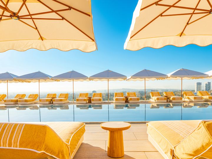 Área de la piscina al aire libre con divanes y sombrillas