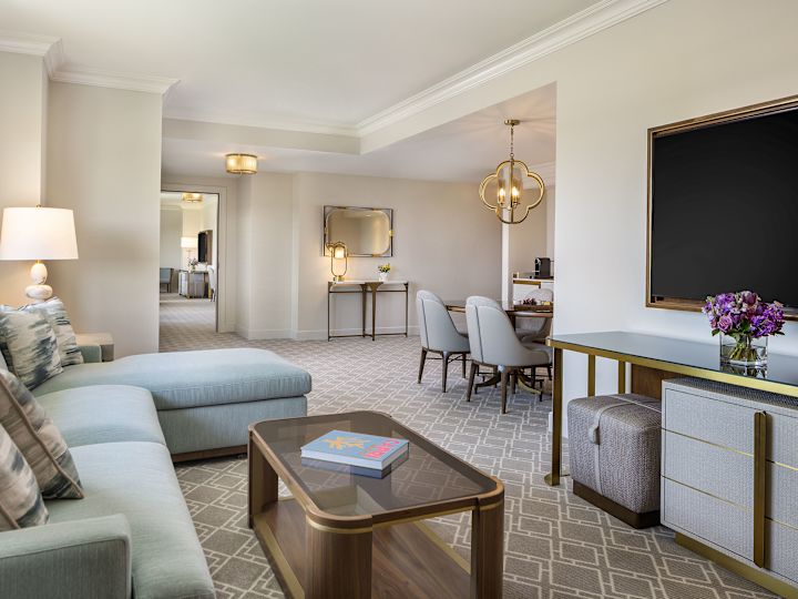 Grande salle de séjour d'une suite avec téléviseur et vue partielle sur le coin repas