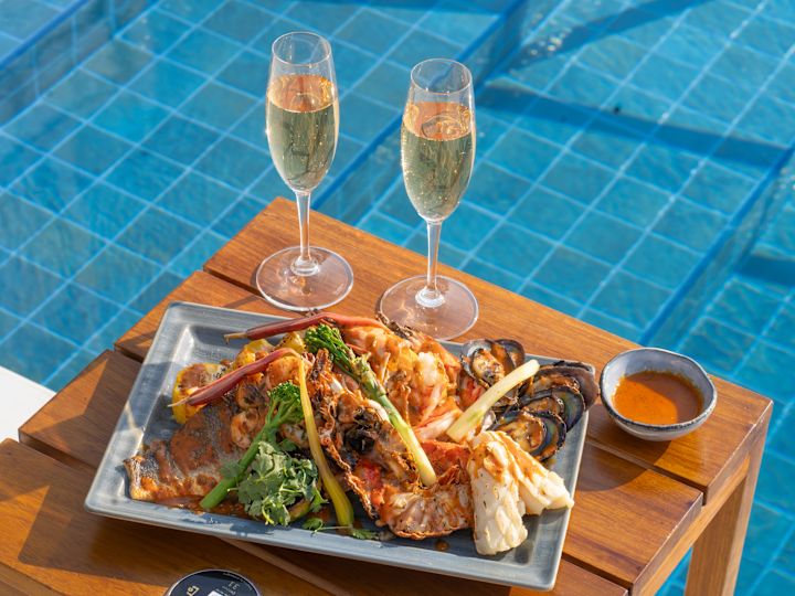 Sunset Beach Lounge with some food on wooden table  by pool
