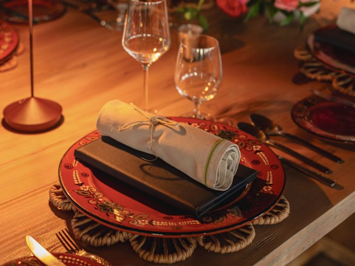 mesa del restaurante con vajilla, copas de vino y flores frescas