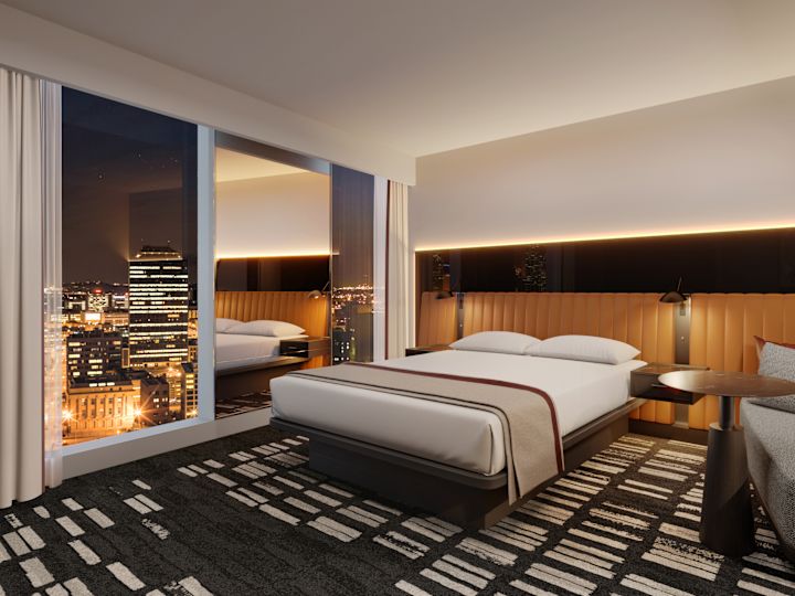 Zimmer mit KingKingsize-Bett, Lounge-Schlafsofa und Panoramafenstern mit Stadtblick