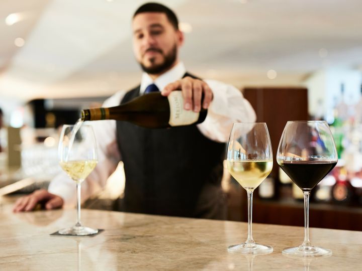 Happy Hour in der ATRIO Wine Bar & Restaurant, Barkeeper schenkt Wein
