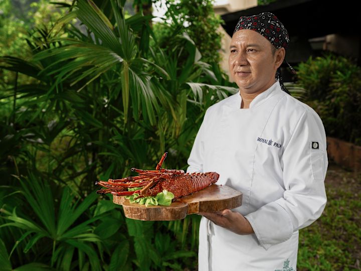 Kock som håller en hummerdisk på Royal Palm Restaurant
