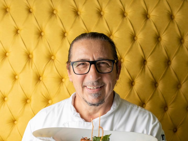 Chef Andrea Mugavero holding a plate of food