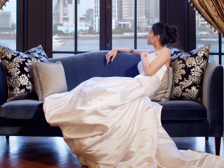 Bride Sitting on a Sofa Looking Out a Window