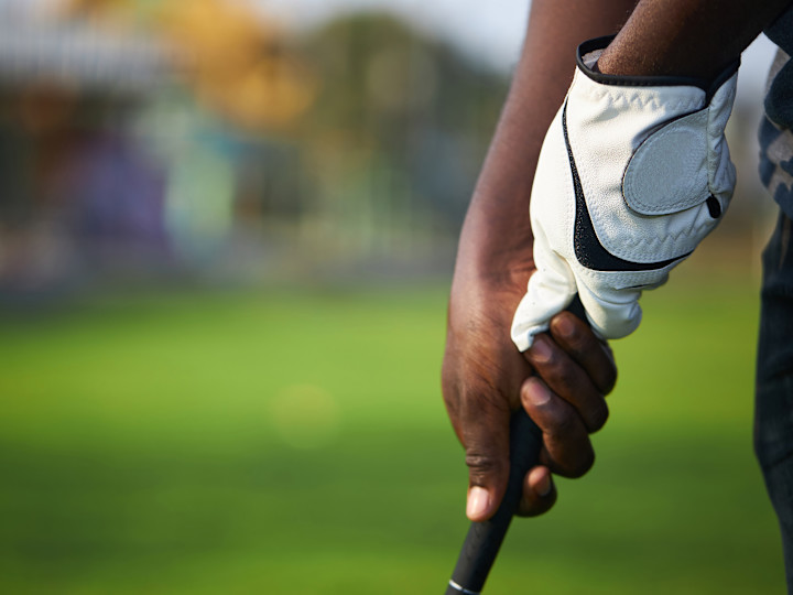Acara golf yang menampilkan orang yang memegang tongkat golf